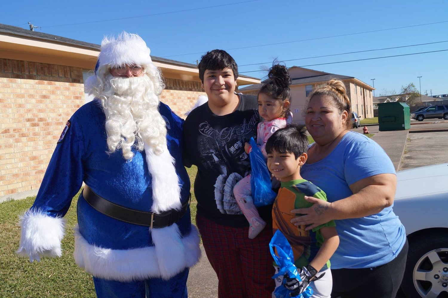 Blue Santa with a family and Christmas gift bags